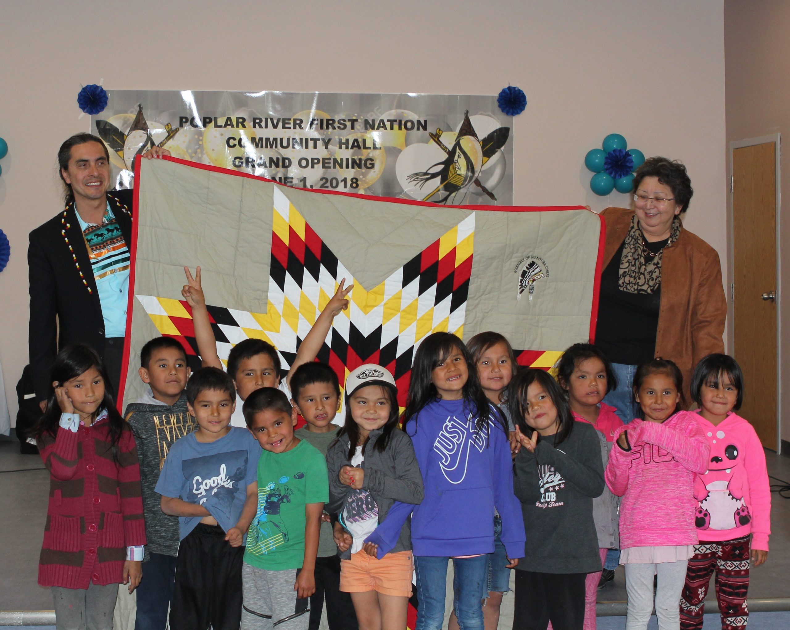 Grand Chief Dumas presents Chief Vera Mitchell and community members with a star blanket