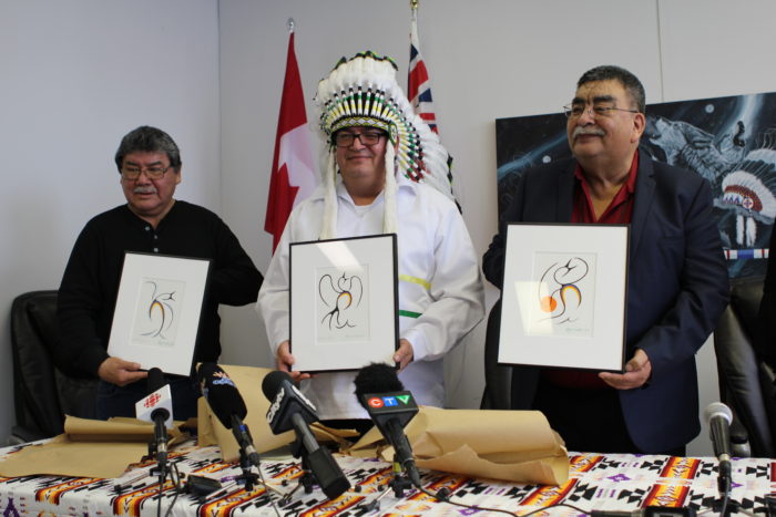 Three Chiefs from Manitoba holding artwork